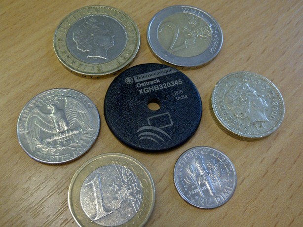 An image showing a RFID Tag next to different coins