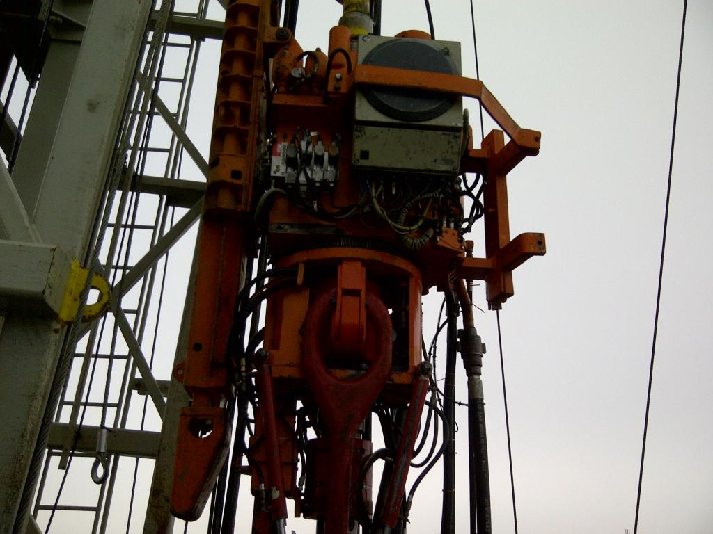 Showing a Top Drive in operation on an onshore Drilling Rig